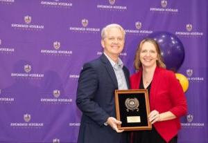 Dr. Jill Jumper accepting her award from President Bruntmyer on stage.